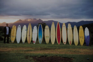 Simon Anderson standing with surfboards